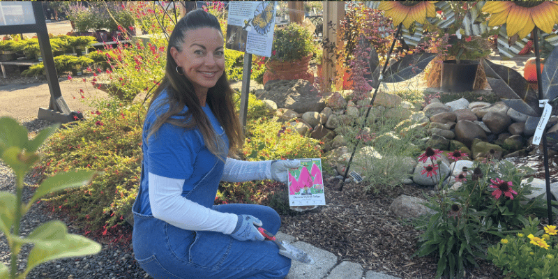 Woman with bulbs and garden tool planting bulbs for spring color